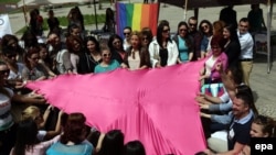 Rights activists of the LGBT community hold a pink triangle, a symbol used in Nazi concentration camps to identify gays and lesbians, on the occasion of the International Day Against Homophobia in Tirana on May 17.