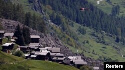 Helikopter spušta opremu u selu Blaten na koje se urušio glečer u Švajcarskoj, 29. maja 2025. 