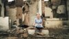 Kazakhstan, Shymkent. A woman in front of a house where a shell fell. According to Shyngys Abdrazak who took the picture of a 70-year-old Zhanagul Baymukhanova is still homeless.