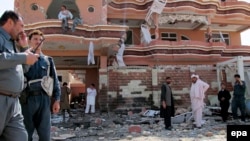 Afghanistan security officials inspect the scene of a suicide car bomb attack that targeted Nawzad district police chief Abdullah Khan near his house in Lashkar Gah, Helmand province, Afghanistan on October 8, 2014. 