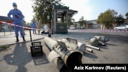 An Azerbaijani investigator stands near fragments of ammunition in a street recently hit by shelling in the town of Barda on October 29.