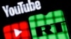 Behind bars is a smartphone with the RT (Russia Today) logo on the background of the Youtube logo. Blocking RT (Russia Today) YouTube channels.