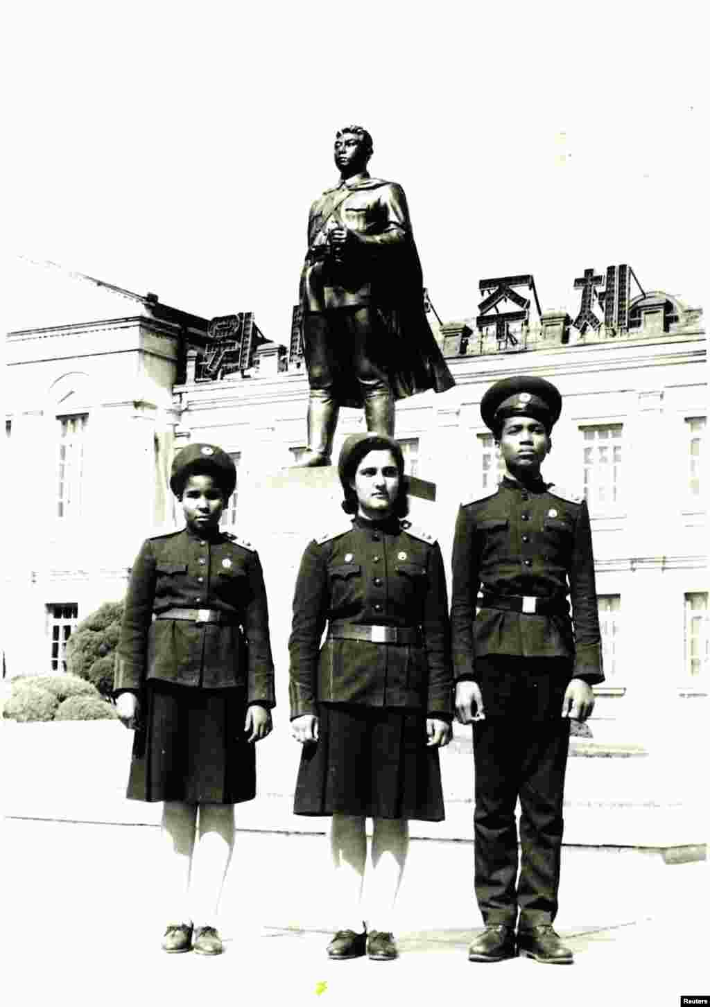 Monique (left) stands in front of the Mangyongdae Revolutionary School with her elder sister, Maribelle (center), and brother Francisco at school in 1989.