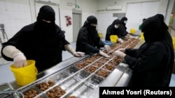 حجاب مرسوم برای زنان در عربستان سعودی؛ کارگاه بسته‌بندی خرما 