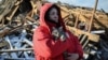 A woman holds her cat as she surveys the damage caused to her house destroyed by a Russian missile strike of the northeastern Ukrainian city of Chernihiv. 