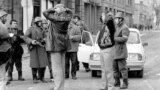 Doi protestatari de la Timișoara sunt chestionați de forțele de ordine în timpul manifestărilor din decemmbrie 1989.