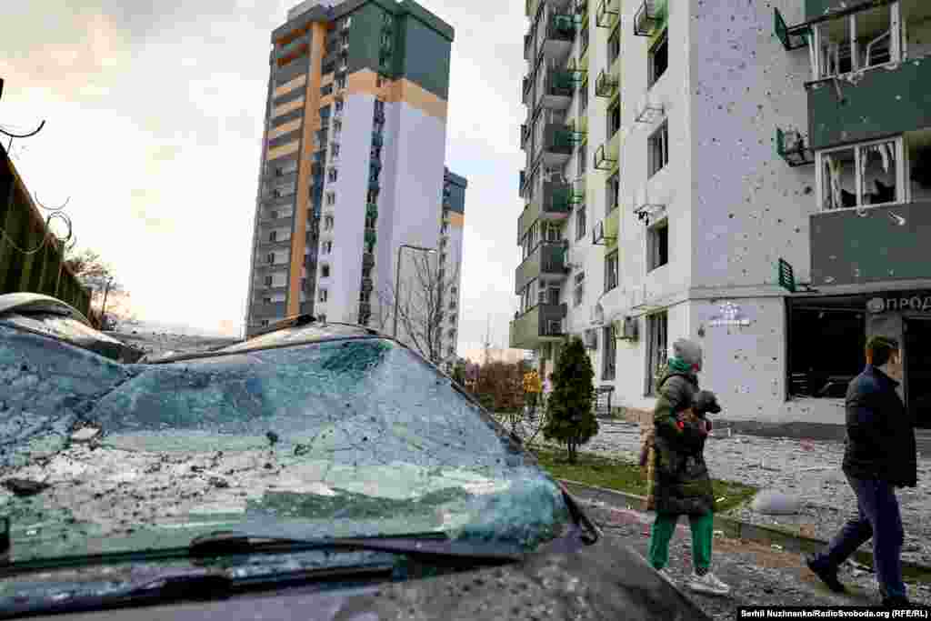 Люди проходять повз один із будинків у Києві, які були пошкоджені внаслідок обстрілу армії РФ цієї ночі, 16 квітня 2026 року