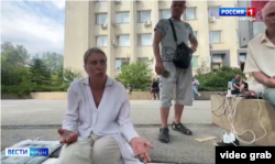 Cкріншот відео сюжету каналу «Россия 1»: жителі Красноперекопська заряджають телефони, сидячи просто неба, 16 липня 2026 року