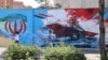 Iranians walk past an anti-US mural in Tehran on June 3.
