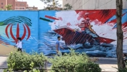 Iranians walk past an anti-US mural in Tehran on June 3.
