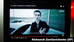 A tablet shows archival YouTube footage featuring Yevgeny Nikulin in 2017.