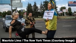 25 августа 2014 года, Донецк. Снимок, сделанный фотографом Маурисио Лима специально для New York Times, на котором избивают привязанную к столбу Ирину Довгань