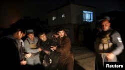Afghan policemen carry a wounded man at the site of an explosion in Kabul, Afghanistan on January 1.