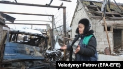 A local woman reacts near her house, damaged during recent shelling, in the village of Novoluhanske in Donetsk region on December 20.