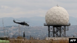Вертолет идет на посадку на территории российской военной базы в сирийской провинции Латакия. 16 декабря 2015 года.