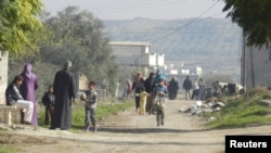 Residents flee their homes after shelling by government forces at Houla, near Homs, in early December.