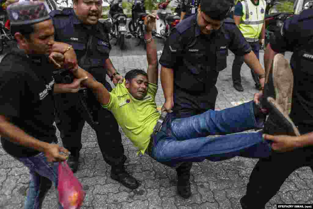 Royal Malaysia Police officers detain a Rohingya Muslim protester from Burma during a demonstration in Kuala Lumpur, Malaysia.