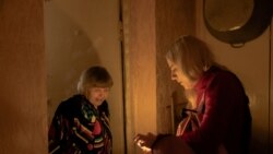 Волонтер и жительница дома в Киеве, оставшегося без отопления и света, 26 января 2026 года