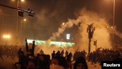 Egypt -- Anti-government demonstrators walk away after teargas was released to disperse them in downtown Cairo, 26Jan2011