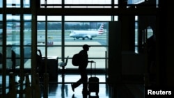 Një pasagjer duke ecur nëpër Aeroportin Ndërkombëtar Ronald Reagan në Arlington, Virxhinia, SHBA, 15 mars 2026.