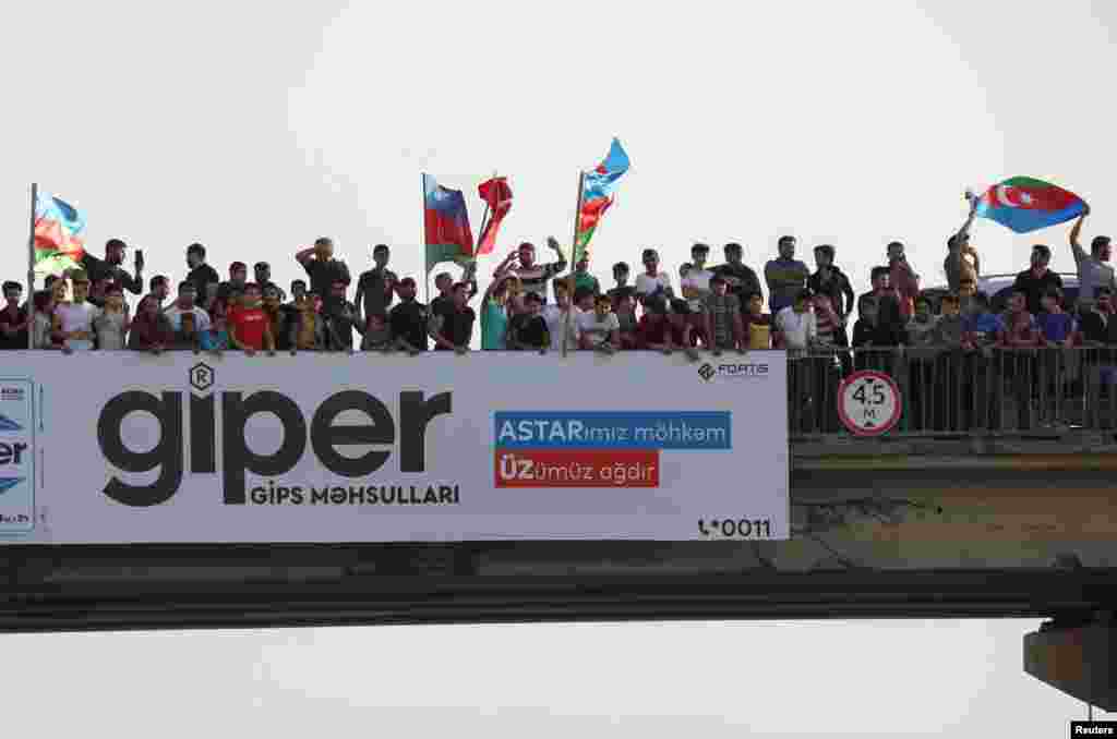 People gather on an overpass to cheer Azerbaijani soldiers in Baku shortly after the breakout of the current conflict in Nagorno-Karabakh on September 27.&nbsp;