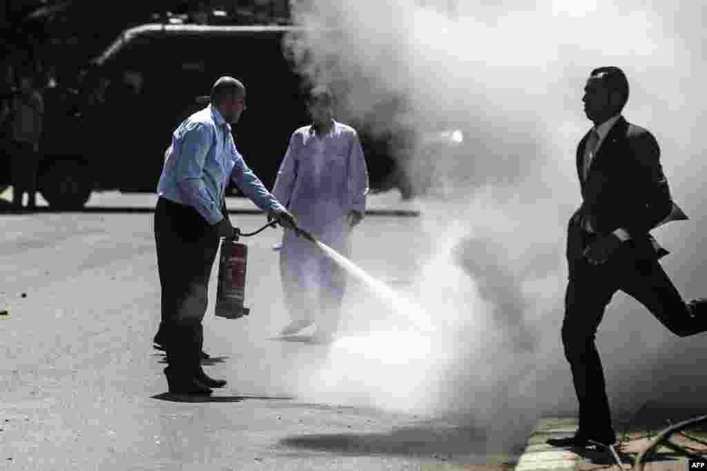 An Egyptian policeman extinguishes a fire during clashes with Muslim Brotherhood supporters following a rally marking the first anniversary of a brutal Cairo crackdown on August 14 in Cairo. (AFP/Mohamed el-Shahed)