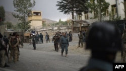 Afghan security personnel gather at the site of a suicide car bombing near Kabul on September 16.