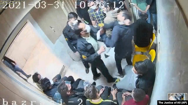 In another frame grab from the hacked video, a guard beats a prisoner at Evin prison.