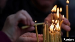 Qirinj ndizen gjatë meshës së Krishtlindjes ortodokse.