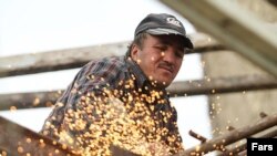 Iran – A worker performing welding in a steel factory, undated