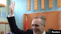 Former presidential candidate Uladzimir Nyaklyaeu flashes the victory sign before his court hearing.