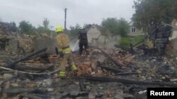 Firefighters work at the site of residential houses destroyed during a Russian missile strike in the town of Zviahel, Zhytomyr region, Ukraine, on June 9.