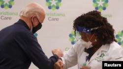 Presidenti i zgjedhur i SHBA-së, Joe Biden pas marrjes së vaksinës kundër koronavirusit, përshëndetet me një punonjëse shëndetësore. 