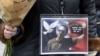 A woman holds a picture of Samuel Paty at a rally in Lille on October 18, 2020, two days after he was beheaded by an attacker who was shot dead by policemen.