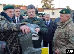 Petro Poroșenko examinând uniforme militare.