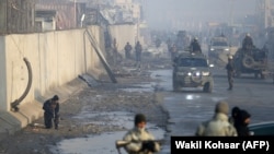 Сотрудники сил безопасности Афганистана близ места взрыва, неподалеку от укрепленного квартала. Кабул, 15 января 2019 года.