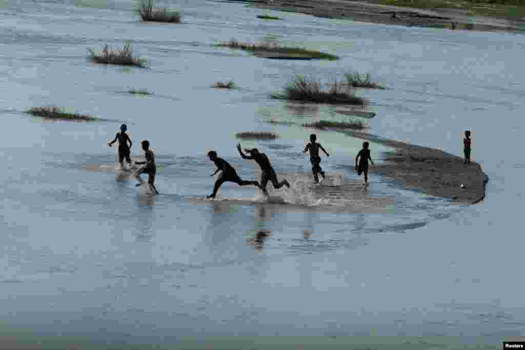 Fëmijët freskohen në lumin Nagoman në periferi të Peshavarit, Pakistan.