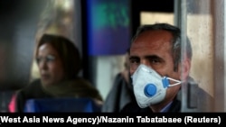 Tehran, Iran - An Iranian man wears a protective masks to prevent contracting coronavirus, as he sits in the bus in Tehran, Iran February 25, 2020.