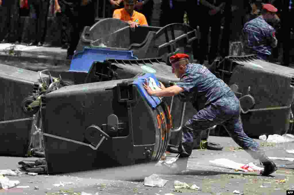 Armenian police officers remove barricades erected by demonstrators protesting against electricity price hikes in central Yerevan on July 6. (AFP/Photolure/Vahram Baghdasarian)