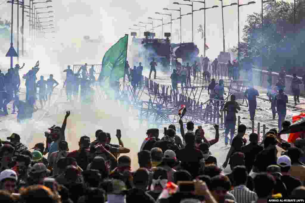 Protesters clash with Iraqi riot police during a demonstration against state corruption and poor services between Baghdad&#39;s Tahrir Square and the high-security Green Zone district on October 1. (AFP/Ahmad al-Rubaye)