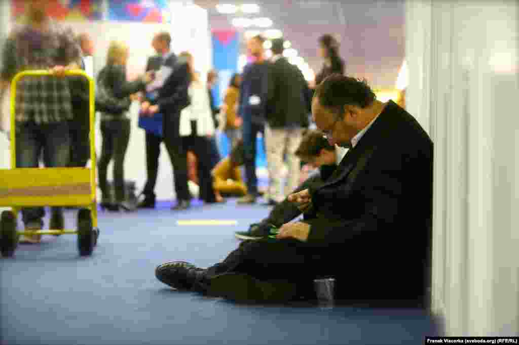 A journalist takes a seat on the floor near the short film section of the festival.