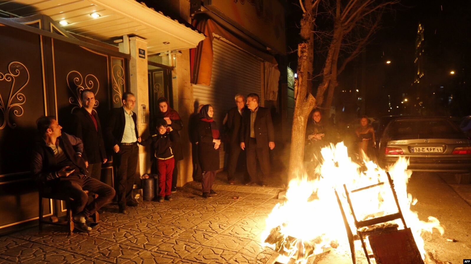 Iranian families light fire outside their houses in Tehran on March 13, 2018 during the Wednesday Fire feast, or Chaharshanbeh Soori, held annually on the last Wednesday eve before the Spring holiday of Noruz. The Iranian new year that begins on March 20