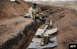 A Ukrainian serviceman sits by a trench at a position held by Ukrainian troops not far from the eastern Ukrainian city of Horlivka in the Donetsk region on March 4.