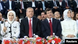 Turkish Prime Minister Tayyip Erdogan (2nd left) and Foreign Minister Ahmet Davutoglu (2nd right) are accompanied by their wives, Emine Erdogan (left) and Sare Davutoglu (right), as they attend the Extraordinary Congress of the ruling AKP on August 27.