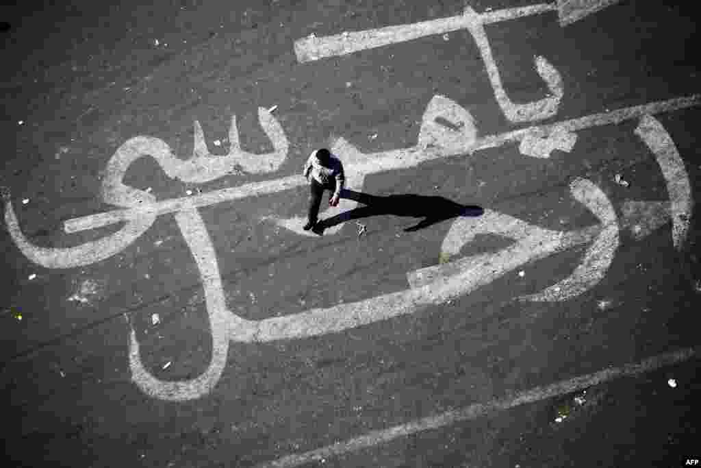 An Egyptian man walks over graffiti reading &quot;Morsi Go&quot; in Egypt&#39;s Tahrir Square in Cairo. Violent clashes have occurred in Egypt after President Muhammad Morsi issued a constitutional declaration granting himself powers to hand down decisions and laws that cannot be challenged in courts. (AFP/Mahmoud Khaled)