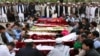 People gather to attend a funeral for the victims of the market blast at a graveyard in Quetta on April 12.