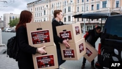 Moscow gay-rights activists carry boxes reportedly containing signed petitions calling for a probe into reported abuse in Chechnya in May 2017.