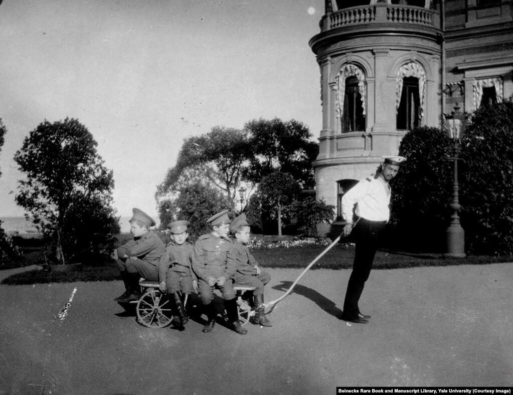 Klementy Nagorny (right) was also tasked with looking after Tsarevich Aleksei (second from right on trolley). After the 1917 revolution, Nagorny joined the royal family in captivity despite knowing it was likely he would be killed. While imprisoned with the Romanovs, he intervened to stop a Bolshevik guard from stealing Aleksei&#39;s gold chain; he was shot a few days later.