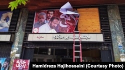 A worker removing the poster of Iranian film The Parental House after it was banned by authorities during its screening. October 29, 2019