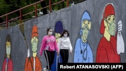 Maqedoni e Veriut: dy vajza ecin pranë një muri me grafite me temë nga pandemia. Fotografi ilustruese. 